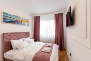 a bedroom with a large bed with red curtains at Apartman 51 Sarajevo in Donje Mladice