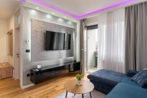 a living room with a blue couch and a tv at Apartman 51 Sarajevo in Donje Mladice