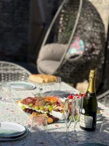 a table with a bottle of wine and a plate of food at Luxury Georgian home, hot tub, sea view, private garden, sleeps 6 in Bognor Regis