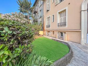 a yard with green grass in front of a building at Studio Centre Ville proche TRAM & Port, Wifi Gratuit in Nice