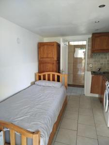 a bedroom with a bed and a kitchen with a sink at Smallest bird's HAVEN in Bloxwich