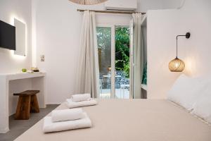 a bedroom with a large bed with towels on it at Tegame Apartments in Pythagoreio
