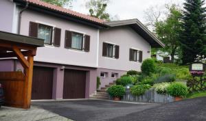 a house with a fence and a garage at Ferienwohnung in Gamlitz +5 photos