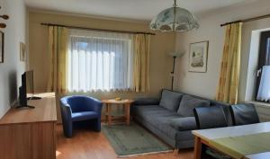 a living room with a blue couch and a table at Ferienwohnung in Gamlitz