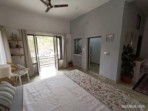 ダルムシャーラにあるRiversongのベッドルーム(大きな白いベッド1台、ガラスのスライドドア付) +10枚の写真