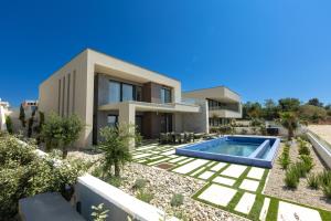 a villa with a swimming pool in front of a house at Adria Resort SEAFRONT Villa C Private Pool Pet Friendly in Zaton