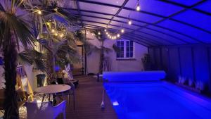 a swimming pool in a room with blue lighting at Strefa ZEN z Jacuzzi i Basenem in Żerniki Wroctawskie
