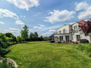 a large yard in front of a white house at Strefa ZEN z Jacuzzi i Basenem in Żerniki Wrocławskie