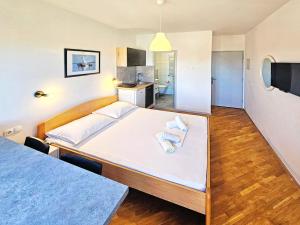 a bedroom with a large bed with towels on it at Apartments & Rooms Strčić Krk in Krk