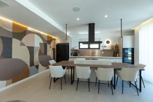 a kitchen with a wooden table and white chairs at Adria Resort SEAFRONT Villa C Private Pool Pet Friendly in Zaton