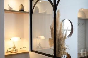 une pièce avec un miroir et deux lampes sur une étagère dans l'établissement Villa Michelet - Jacuzzi - Sauna - Hyper Center, à Tours 61 autres photos
