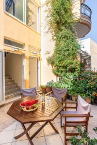 a table with a bowl of watermelon on a patio at Seatherial Apartments Paleochora in Palaiochóra
