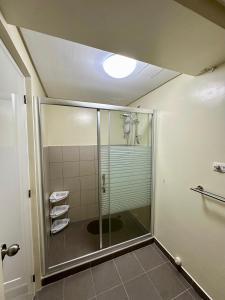 a shower with a glass door in a bathroom at Tagaytay Staycation - Balaico 2 balconies Taal View 2BR in Tagaytay