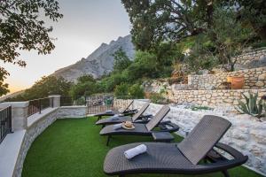 a row of chairs sitting on top of a lawn at Villa Lota - Makarska Exklusiv in Baška Voda