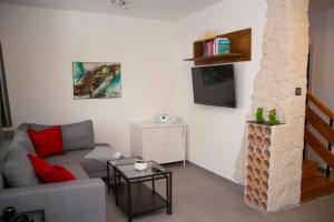 a living room with a couch and a tv at Villa BiBo in Linardići