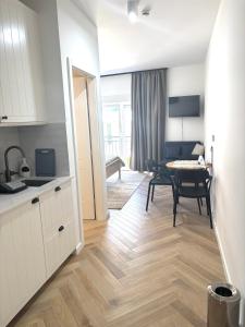 a kitchen and a living room with a table and a dining room at STELLA'S BEACHFRONT Aparthotel in Split