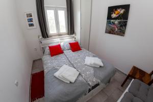 a bedroom with a bed with two red pillows at Villa BiBo in Linardići