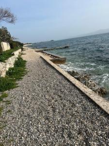 a rocky beach with a pier in the water at Apartments Angelo in Bibinje