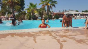 Un grupo de personas en la piscina de un resort. en Le Montourey mobihome, en Fréjus