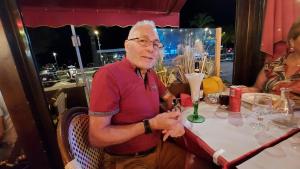 an older man sitting at a table in a restaurant at Le Montourey mobihome in Fréjus