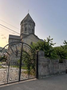 a gate to a church with a tower behind it at Lucy B&B in Goris +9 photos