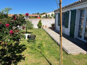 einen Hof mit einem Holzsteg neben einem Haus in der Unterkunft La Villa des Alouettes avec piscine chauffee in Sainte-Marie-de-Ré