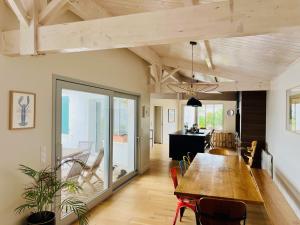 ein Esszimmer und ein Wohnzimmer mit einem Holztisch in der Unterkunft La Villa des Alouettes avec piscine chauffee in Sainte-Marie-de-Ré
