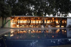 a building with a pool in front of it at Menaka inn in Dhārwād