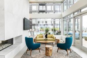 un soggiorno con un divano giallo e sedie blu di Modern Mile High in Sloans Lake a Denver