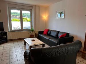a living room with a couch and a table at Aux 2 cerisiers in Virton