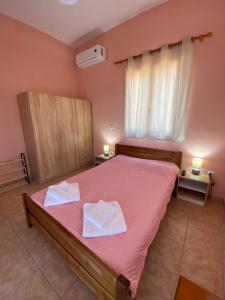 a bedroom with a large bed with two towels on it at Aleka home in Stavros