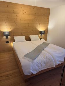 a bedroom with a large bed with two lamps at Chalet Schneelöwe in Bettelried
