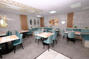 a dining room with tables and blue chairs at Moda Otel in Antalya