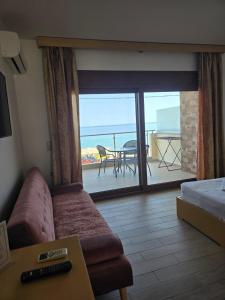 a living room with a couch and a view of a balcony at APARTMENTS by the SEA in Leptokarya
