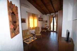 a living room with a couch and a table at Villetta Bouganvillea in SantʼAnna Arresi