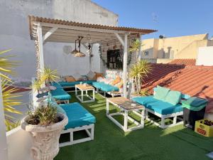 a patio with blue cushioned chairs and a gazebo at Orange Terrace Hostel in Albufeira