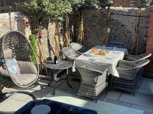 a patio with a table and wicker chairs at Luxury pair of Georgian apartments, hot tub, sea views, sleeps 12 in Bognor Regis