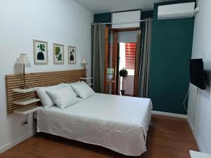 une chambre avec un lit blanc et un mur vert dans l'établissement Bed & Movie, à Rome