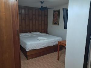 une chambre avec un lit avec une tête de lit en bois dans l'établissement Namtip Bar & Guesthouse, à Pattaya