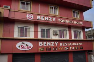 a building with signs on the side of it at Benzy Tourist Home in Ponnāni