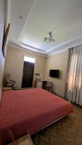 a bedroom with a bed with a red bedspread at Guesthouse Martvili Canyon 'Kolkhi' 