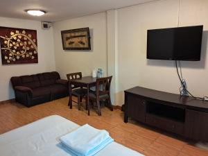 - un salon avec un canapé, une table et une télévision dans l'établissement Namtip Bar & Guesthouse, à Pattaya 12 autres photos