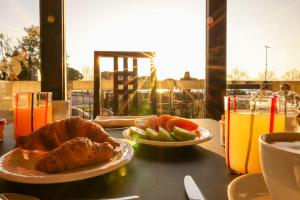a table with two plates of food and oranges and drinks at Alevic Hotel Sirmione in Sirmione