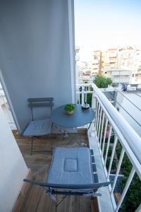 a balcony with a table and a bench on a balcony at vagia's studio in Alexandroupoli