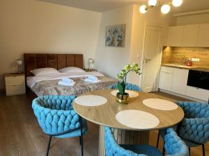 a room with a bed and a table and chairs at Apartamenty Leśna Przystań Kazub in Cieciorka