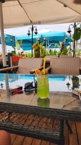 a glass of juice on a table with chairs at ANTALYA Konyaaltı Gündüz Otel in Antalya