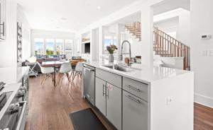 a kitchen and dining room with white walls and wood floors at Moonstruck in Santa Rosa Beach
