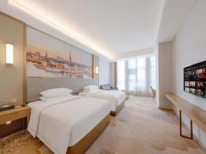 Un pat sau paturi într-o cameră la Vienna Hotel Fuzhou Mawei Banzheng Cultural Scenic Area Branch