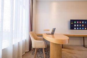 ein Raum mit einem Tisch, auf dem ein Laptop steht in der Unterkunft Vienna Hotel Fuzhou Mawei Banzheng Cultural Scenic Area Branch in Fuzhou