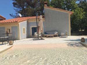 a patio with an umbrella and a couch and a table at Lamaisonbleue in Auriol
